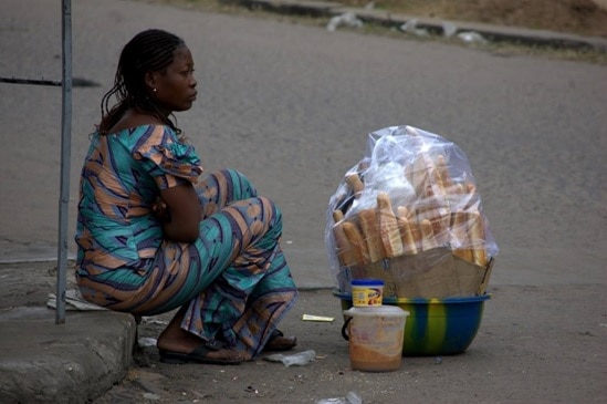 Tôt le matin, une femme s’assoie au bord de la route pour vendre les pains aux premiers passants